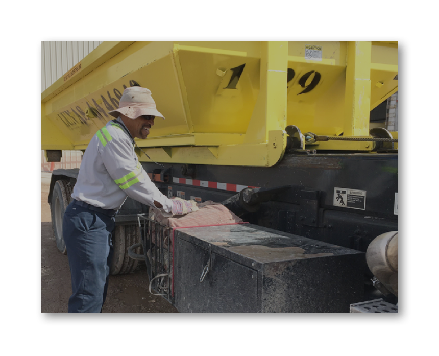 Lunas crew delivering a yellow roll-off dumpster on a Las Vegas job site